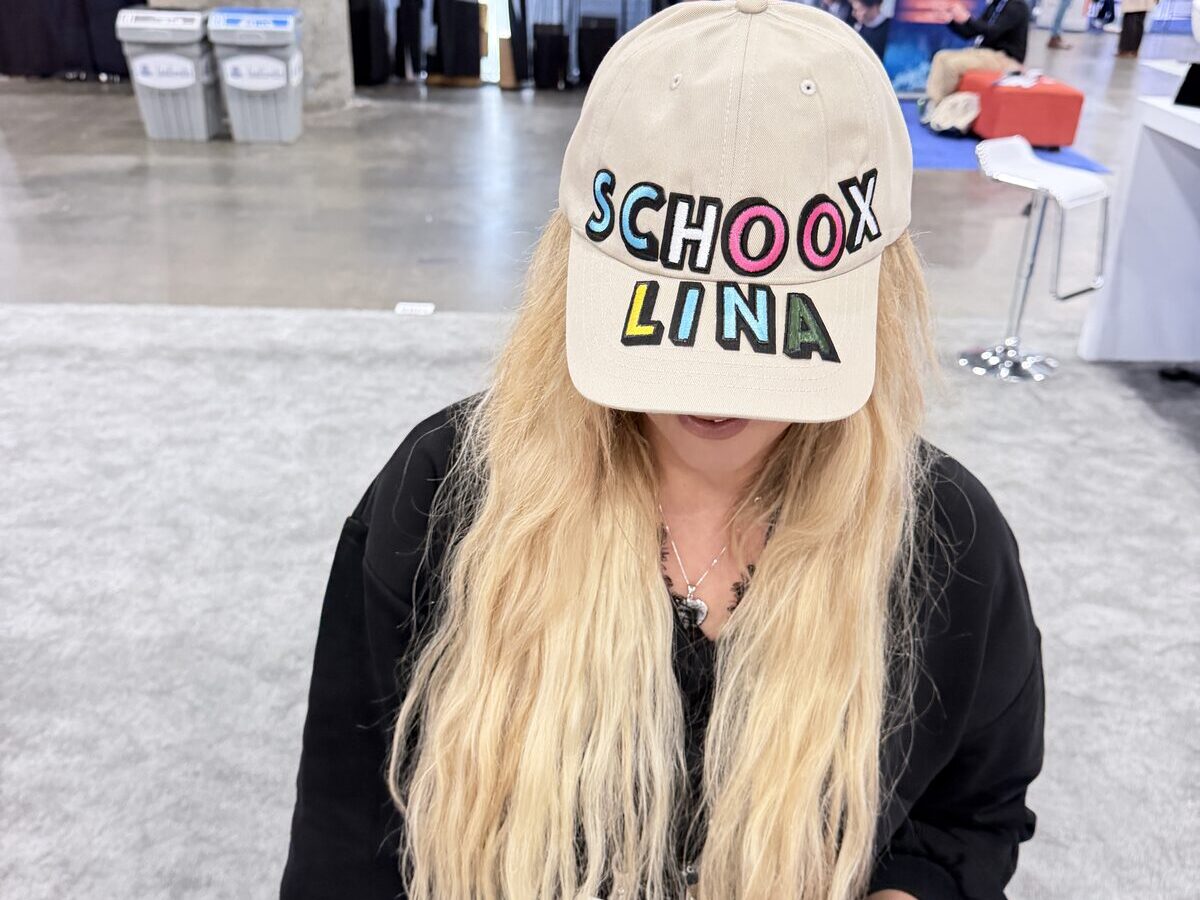 Conference guest wearing a tan cap personalized with colorful chenille letters spelling her name